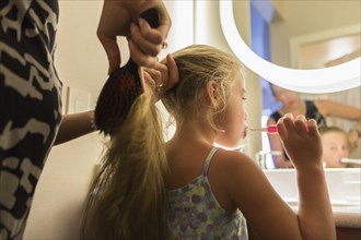 Caucasian mother brushing daughter's hair