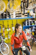 Caucasian woman sitting in bicycle shop
