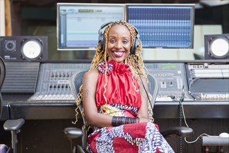 African American singer listening to track in studio