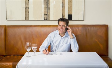 Caucasian businessman on cell phone at restaurant