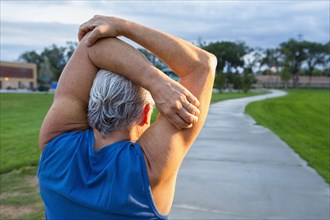 Hispanic man stretching in park