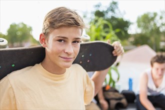 Caucasian teenage boy holding skateboard