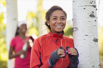 Mixed race teenage girl using binoculars outdoors