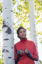 Mixed race girl using binoculars in woods