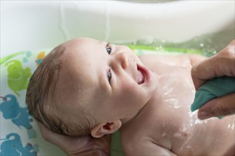 Caucasian mother giving baby boy a bath