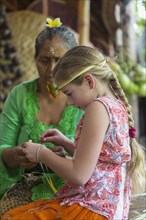 Girl learning Balinese weaving