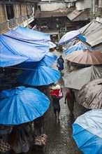 Rain falling over tarps and awnings of market stalls