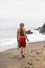 Caucasian girl walking on tropical beach