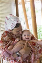 Caucasian mother cradling baby