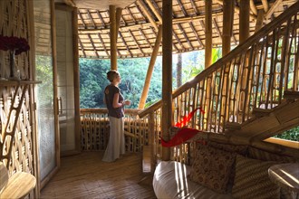 Caucasian woman standing in bamboo room
