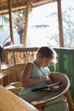 Caucasian girl using digital tablet at patio table