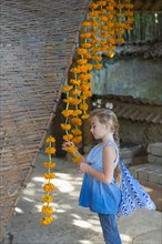 Caucasian girl looking at hanging flower strands