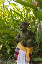 Hindu statue wrapped in fabric in garden