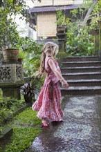 Caucasian girl dancing on wet patio