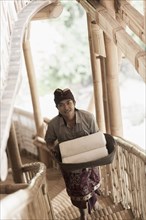 Balinese man carrying rolled towels in hotel
