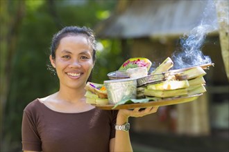 Balinese woman carrying tray of food