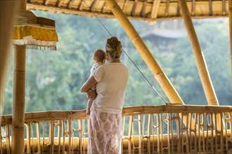 Caucasian mother and baby overlooking view from balcony