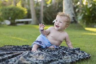 Caucasian baby playing on picnic blanket