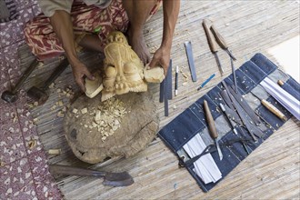 Craftsperson shaping wooden piece in studio