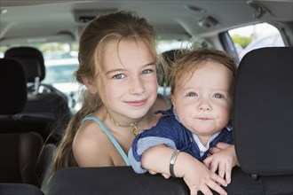 Caucasian children sitting in backseat of car
