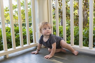 Caucasian baby crawling on porch