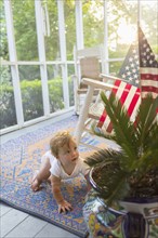 Caucasian baby crawling on porch