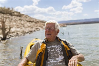 Older Caucasian man rowing on lake