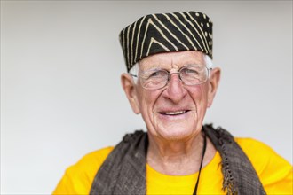 Older Caucasian man wearing striped hat