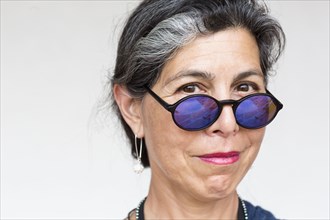 Older Hispanic woman wearing blue sunglasses