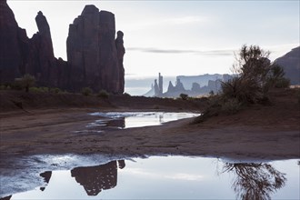 Rock formations overlooking puddles in desert landscape