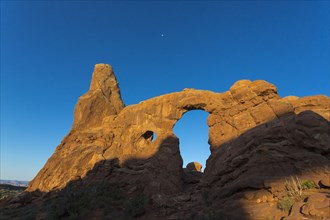Low angle view of Turret Arch rock formation under blue sky