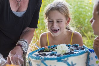 Family celebrating birthday together outdoors