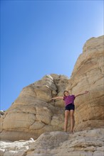 Caucasian girl cheering on rock formations