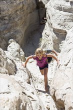 Caucasian girl climbing rock formations