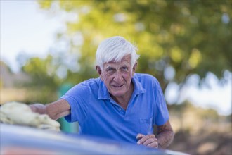 Senior Caucasian man washing car outdoors