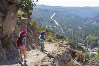 Children hiking together on rocky mountainside