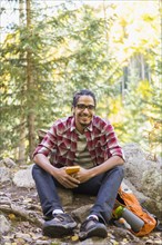 Mixed race hiker smiling in forest