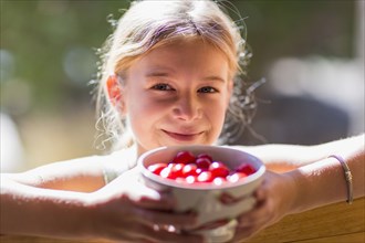 Caucasian girl holding bowl of fruit