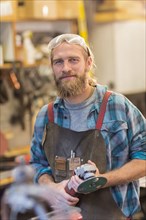 Caucasian craftsman smiling in workshop