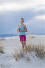 Caucasian girl standing on sand dune