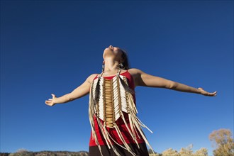 Mixed race woman with arms outstretched in desert