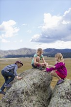 Children exploring rock formations in remote landscape