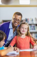 Teacher and student smiling in library