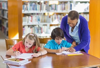 Teacher helping student in library