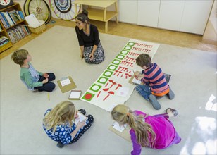 Montessori teacher and students working in classroom