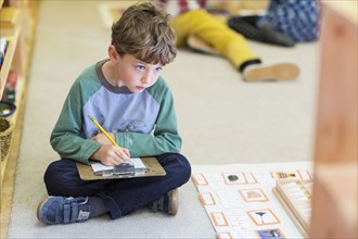 Boy writing in classroom