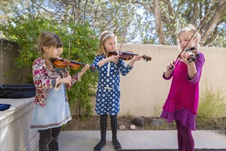 Girls playing violin outdoors