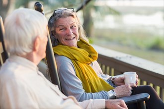 Older Caucasian couple drinking coffee on porch