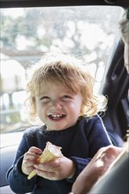 Caucasian baby boy eating ice cream in car