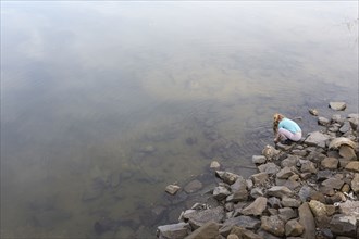 High angle view of Caucasian girl playing at lake